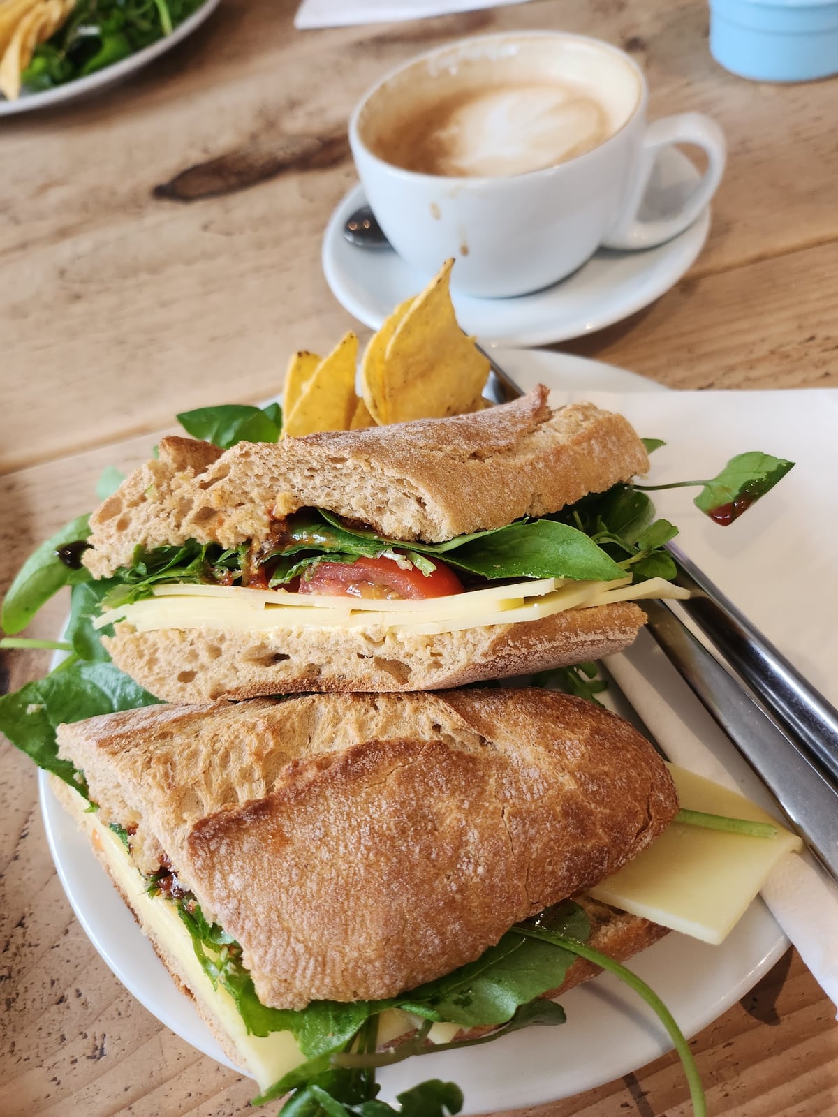 A sandwich and coffee served on a wooden table